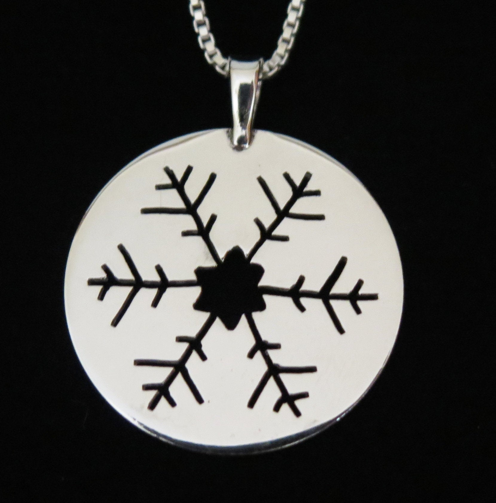 snowflake silhouette hand sawn in 1 1/8 inch sterling silver disc pendant on 18 inch sterling silver chain 